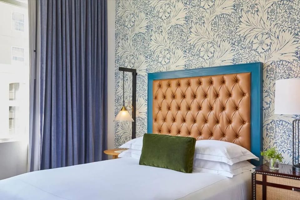 Unwind in crisp linens beneath a bold, tufted headboard.