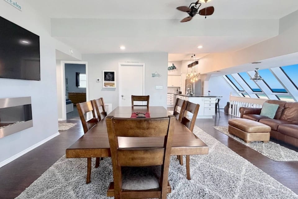 Open-concept living with seating, dining, Smart TV, and full kitchen. Enjoy ocean views from front and side windows with plenty of natural light.