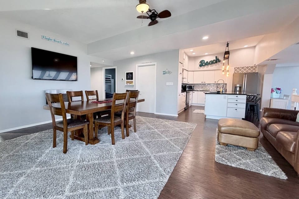 Open-concept living with seating, dining, Smart TV, and full kitchen. Enjoy ocean views from front and side windows with plenty of natural light.