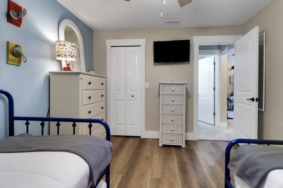 The guest bedroom has a wall-mounted Smart TV with Firestick and a ceiling fan for added comfort.