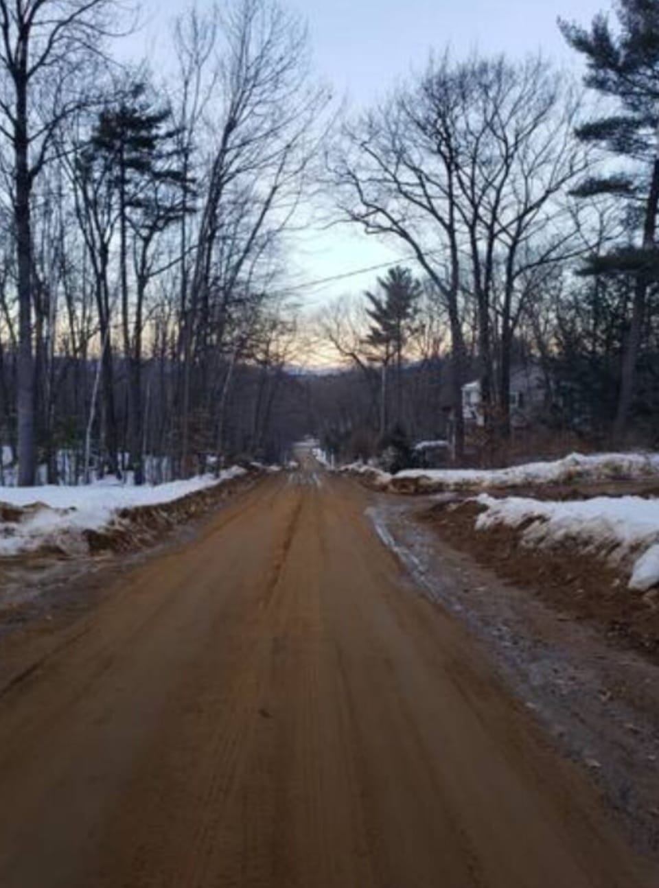 This is the road to the home. It is a dirt road up a hill.