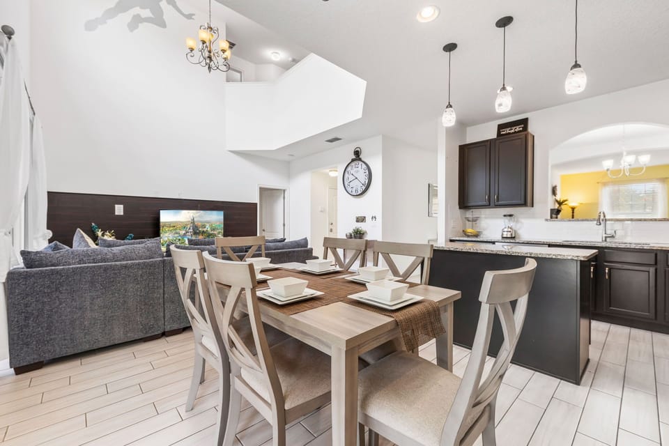 Share delicious meals and create lasting memories in a bright, stylish dining room featuring a large table and modern lighting.
