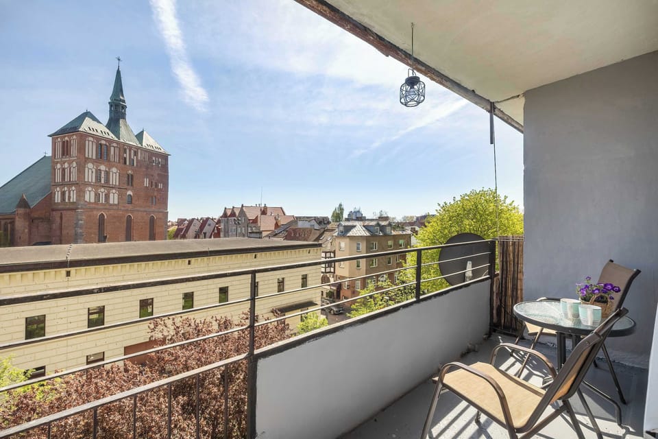 The view from the cozy balcony overlooks a quiet, green area.