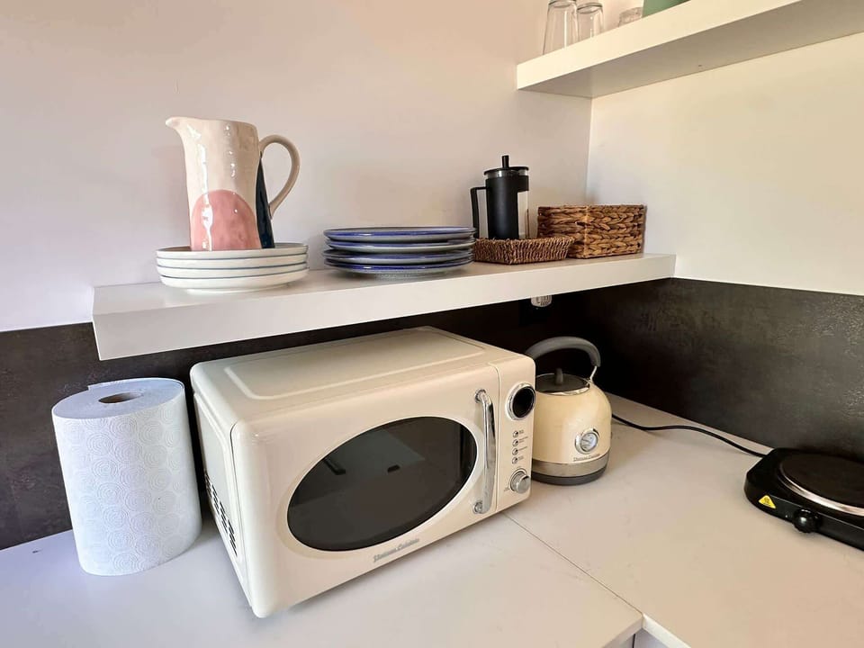 A kitchenette equipped with a microwave, electric kettle. Functional and ready for everyday use.