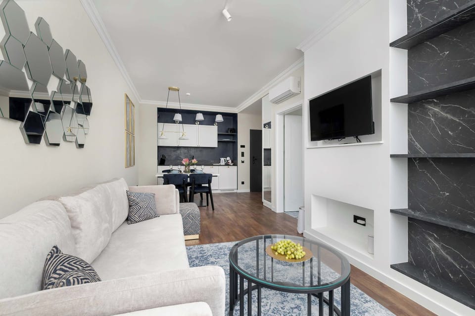 The living area features a sleek coffee table and a flat-screen television.