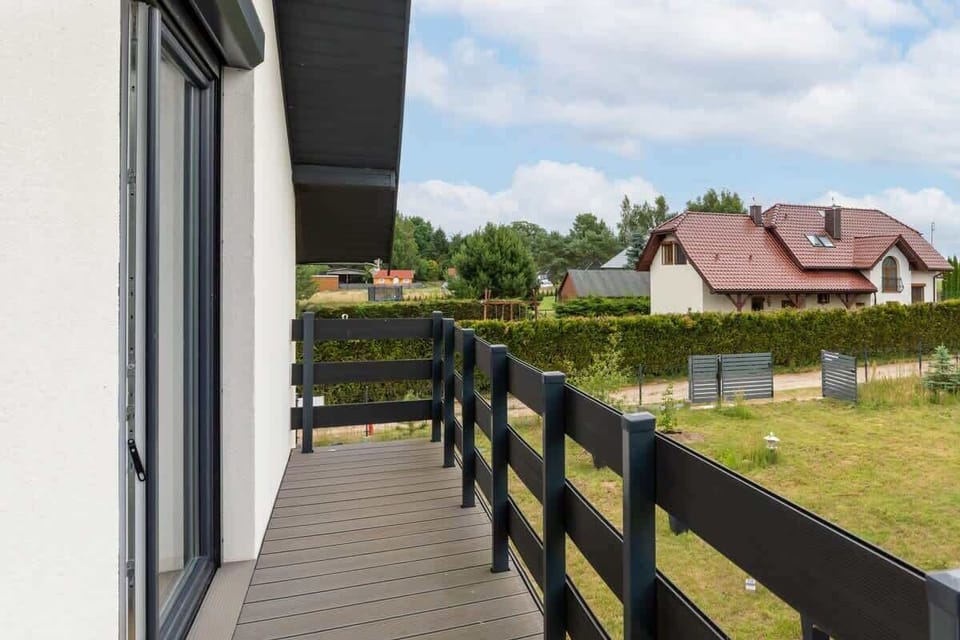 A view of the balcony overlooking the peaceful neighborhood and green surroundings.


