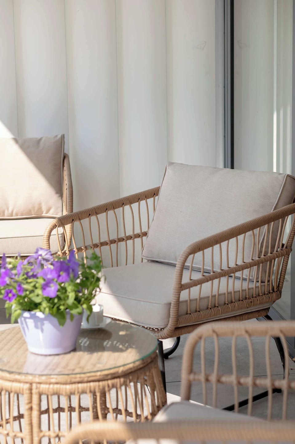 A comfortable rattan chair with soft cushions on the balcony. The perfect spot to relax and enjoy the view.

