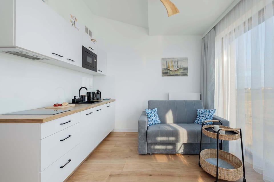 A cozy living room with a comfortable sofa, a coffee table, and large windows bringing in natural light.