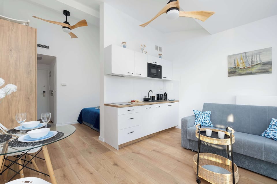 A stylish kitchen with modern white cabinetry, a wooden countertop, and essential appliances.
