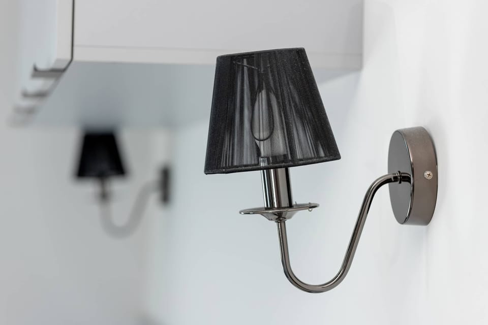 Close-up of a stylish wall lamp next to the bed area.