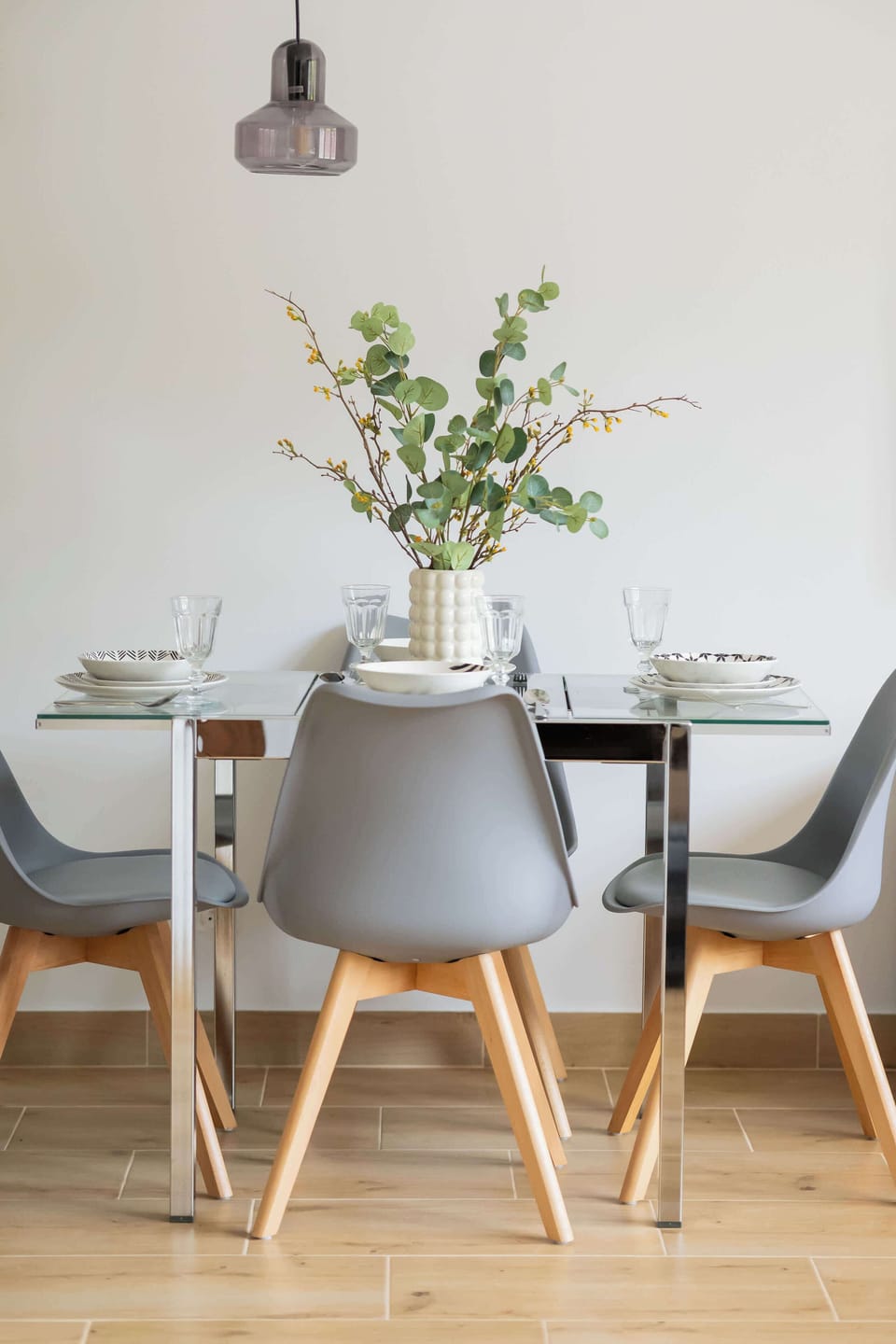 Elegant dining setup with four chairs and a decorative vase on the table.