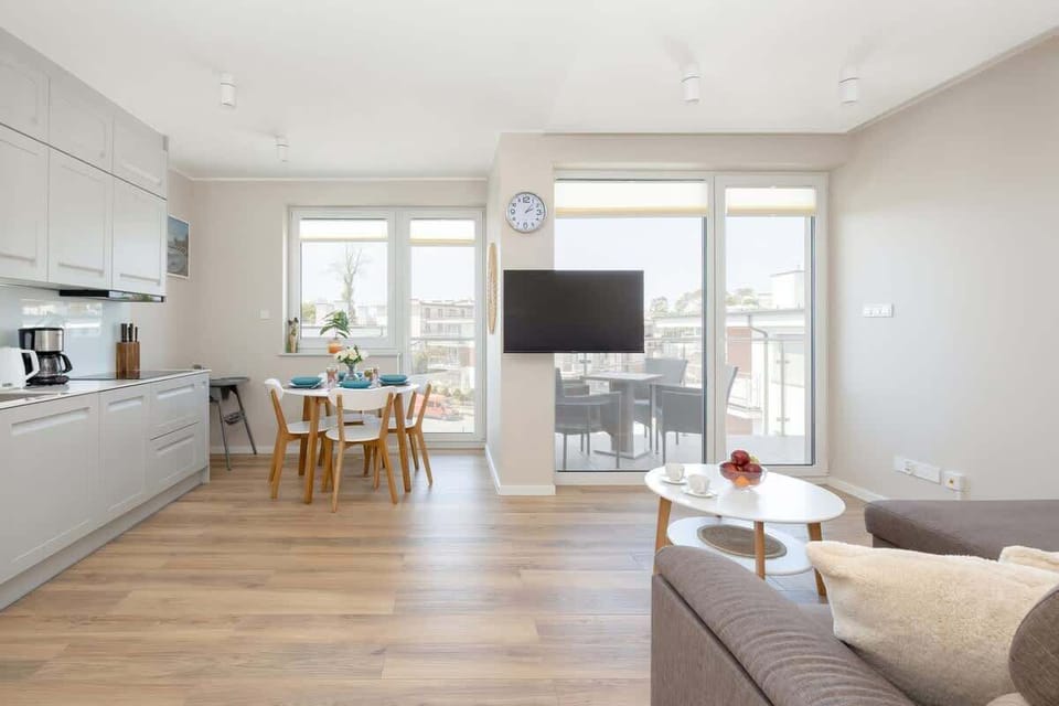 Spacious living area with a sofa bed, TV and kitchenette with dining area.