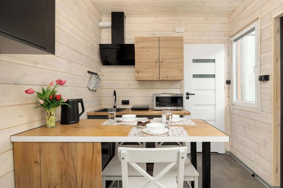Dining and kitchen area featuring wooden cabinets, small appliances, and a compact dining table with stools.