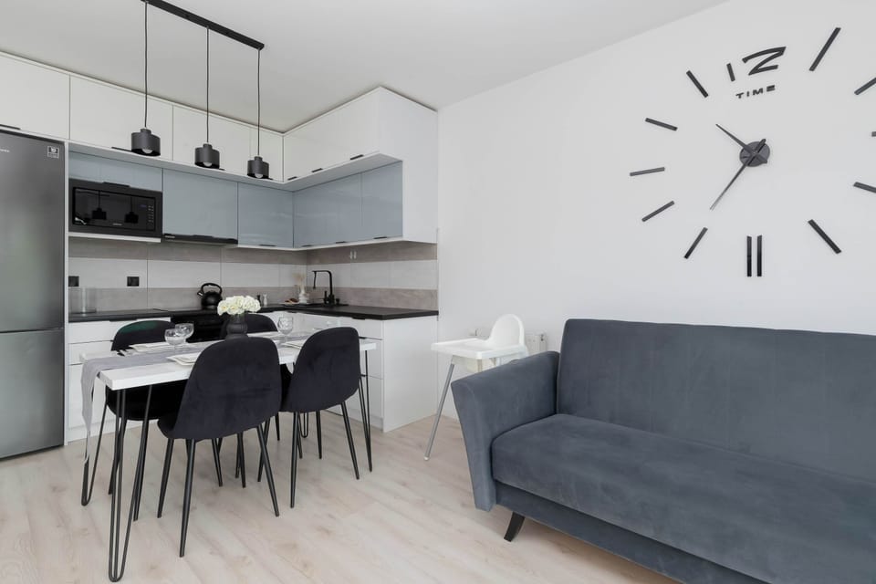 A table for four with comfortable chairs, above the table a modern decorative lamp.