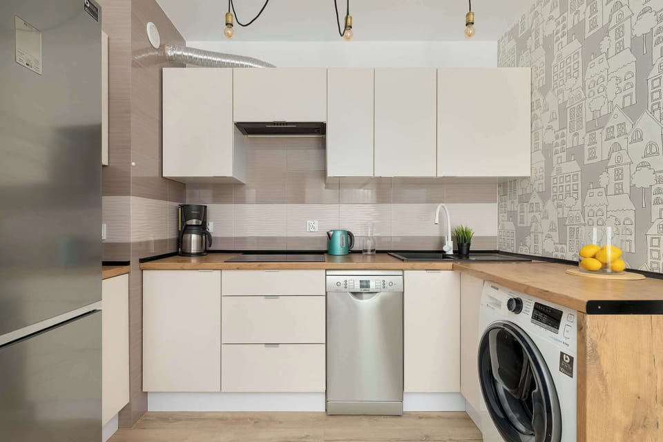 A sleek kitchen with contemporary cabinets and a built-in oven. A fruit bowl adds a touch of color to the clean, modern space.