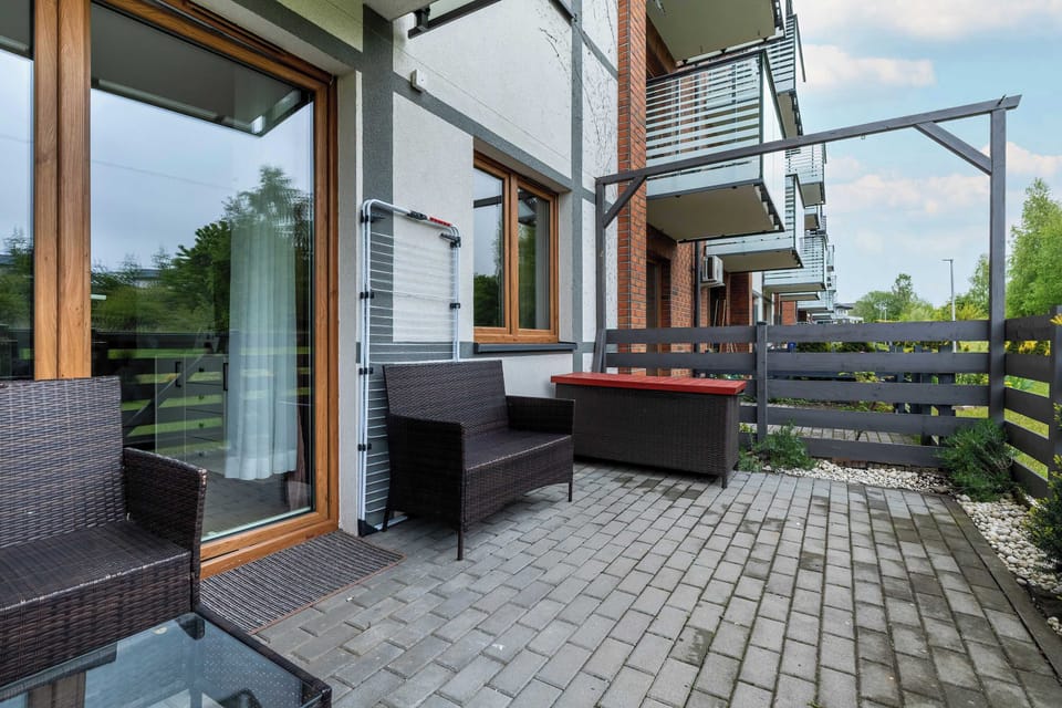 A private terrace with wicker furniture and green surroundings. A great place to unwind outdoors.
