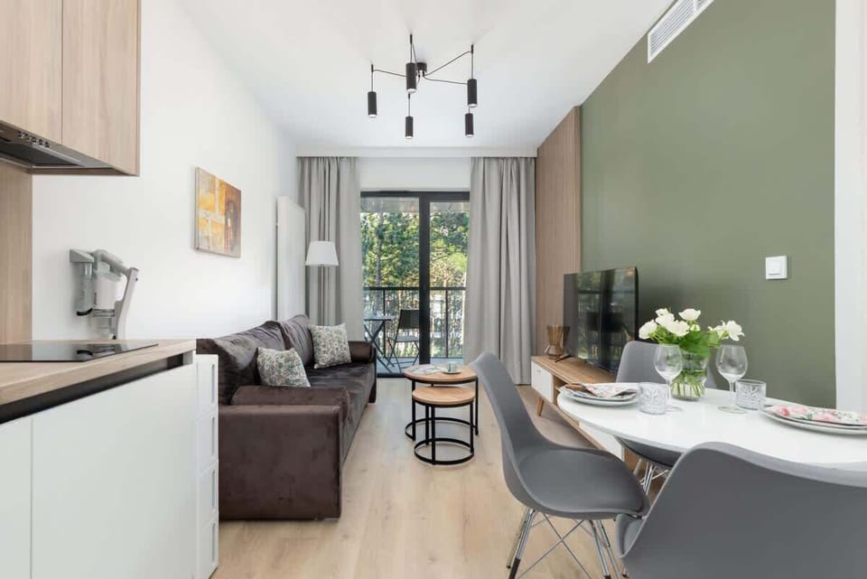 A well-lit kitchen and dining area with contemporary furniture and neutral tones, creating a welcoming atmosphere.

