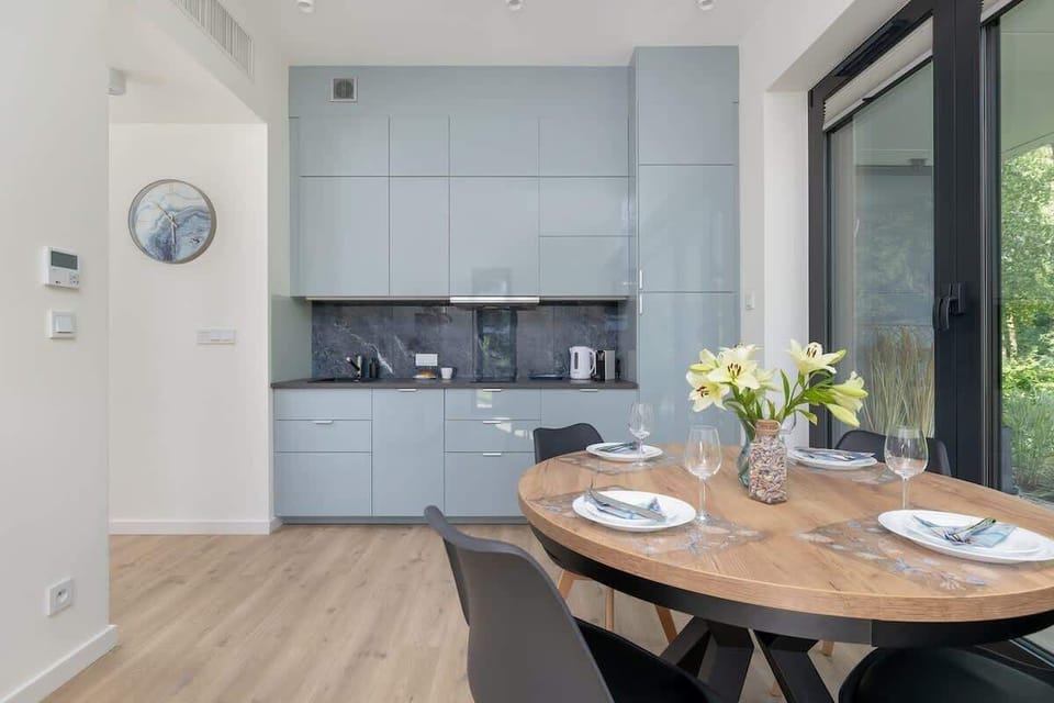 Stylish kitchenette withe cabinets, round table and large window creates a bright, elegant space for shared meals.