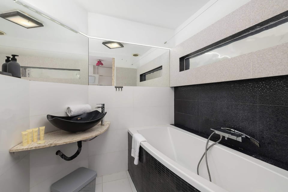 Bright and functional bathroom with a bathtub, a welcoming toiletries set, and towels.