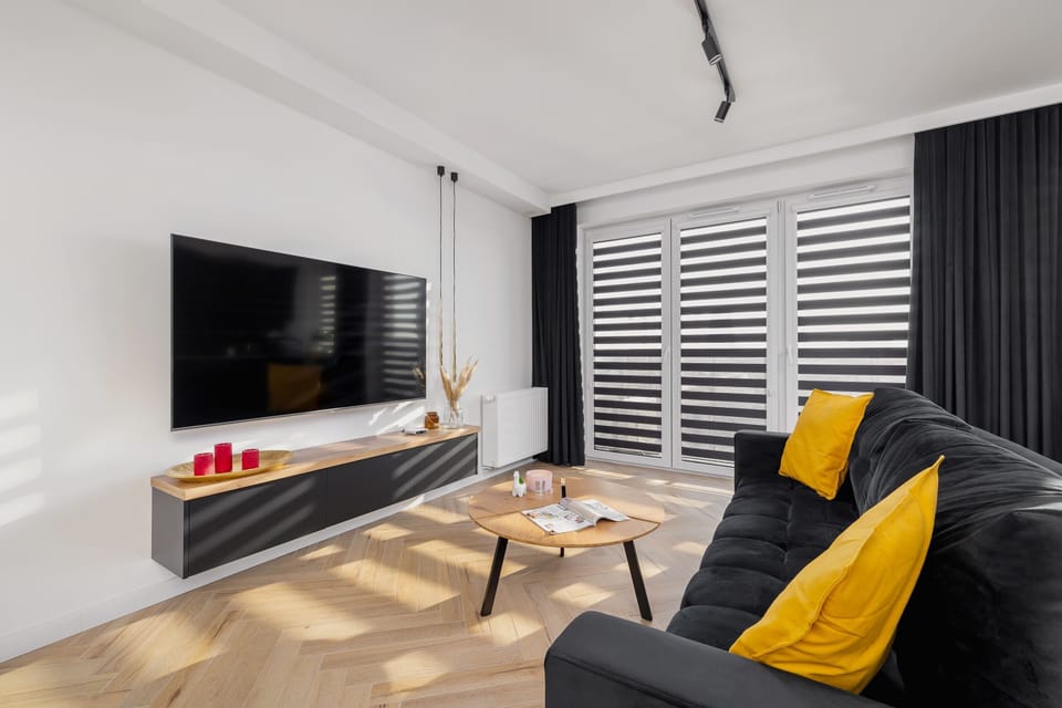 The living area features a sleek coffee table and a flat-screen television.