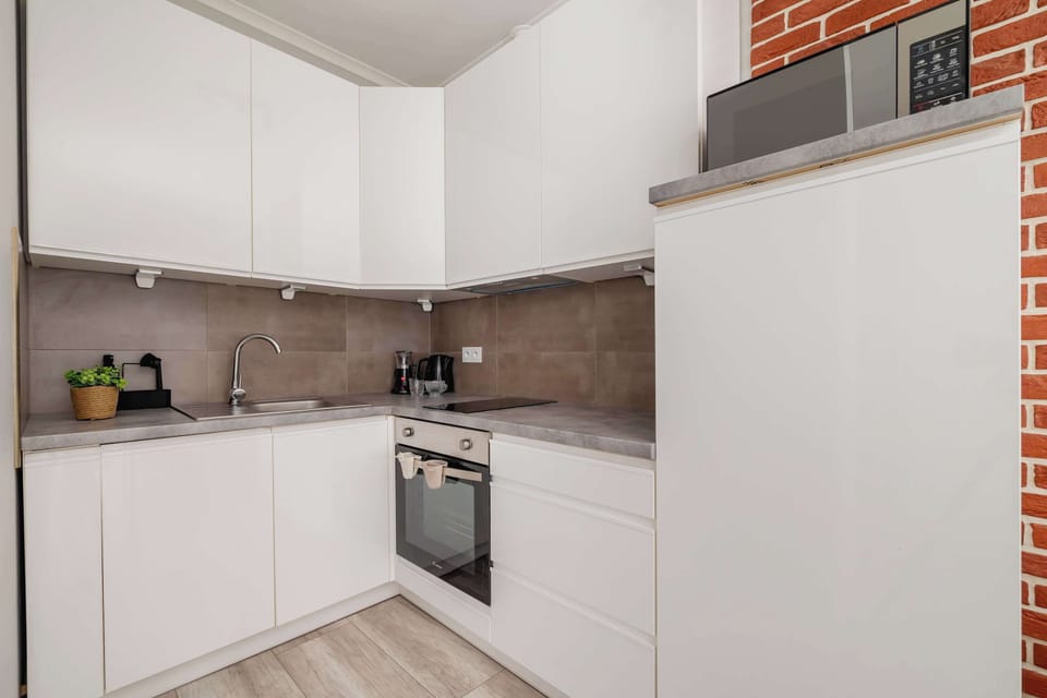 A stylish white kitchen with modern appliances and sleek cabinetry. The open layout makes it practical and inviting.
