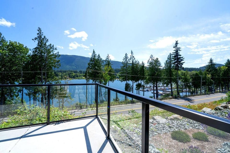 South-facing patio/deck space with outdoor seating, a saltwater hot tub and mountain & lake views.
