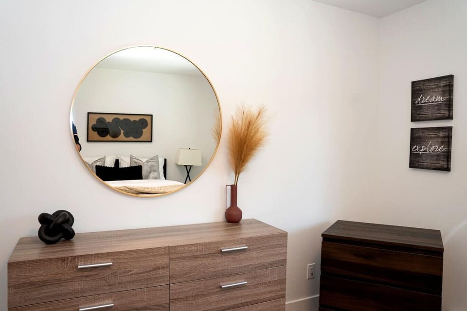 Primary bedroom with a queen bed, dresser, closet and blackout blinds.