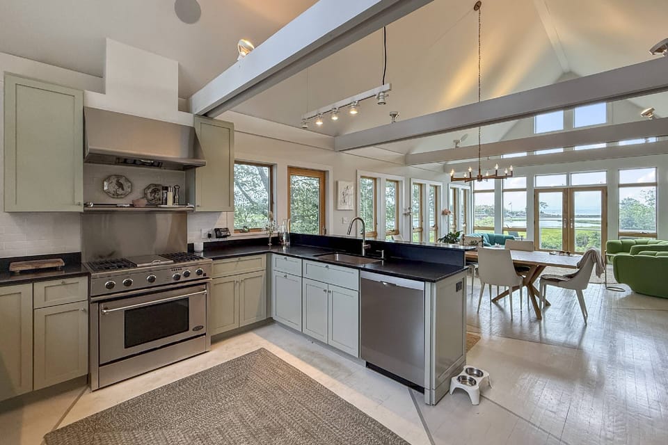 Prepare meals in style with serene creek views and upscale finishes in this stunning waterfront kitchen.
