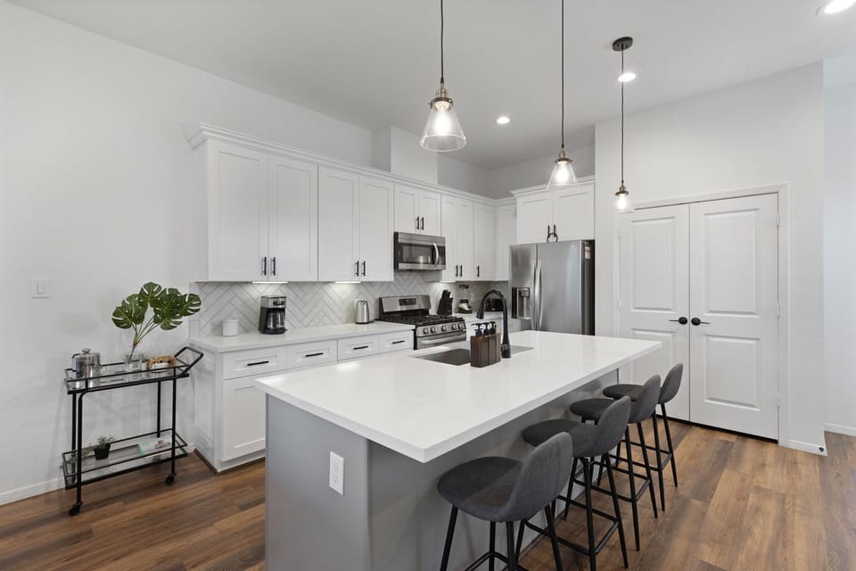 Gourmet Kitchen: Sleek white cabinetry, modern appliances, and an inviting island for culinary adventures!