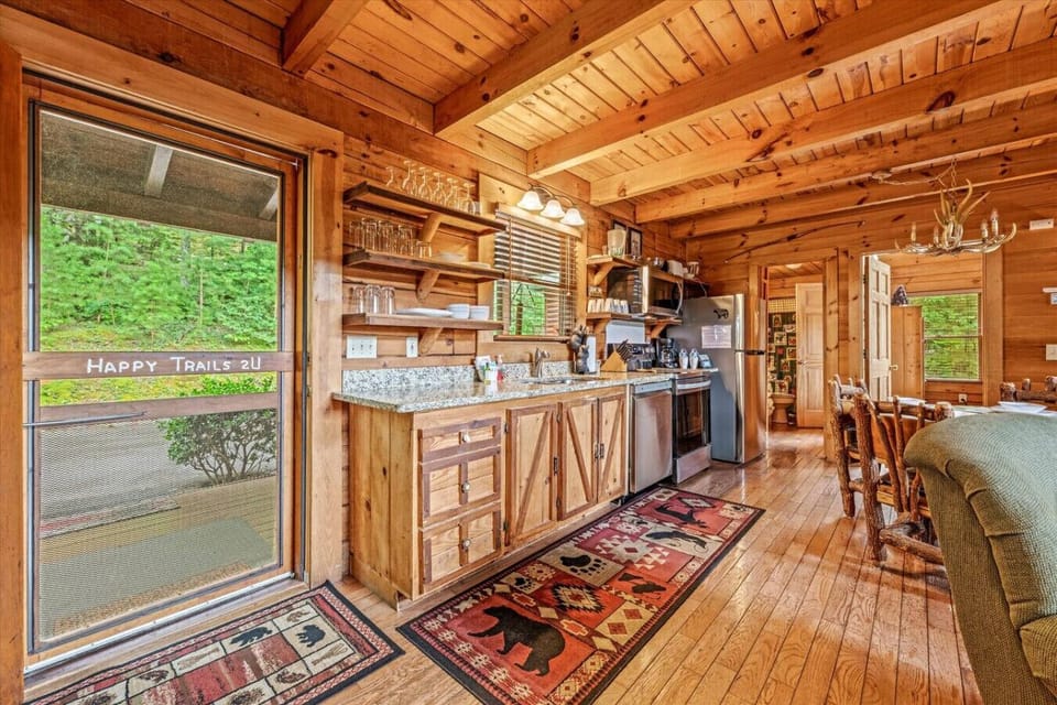 The fully equipped kitchen offers plenty of countertop space, stainless steel appliances, and rustic open shelving stocked with essentials for home-cooked meals.