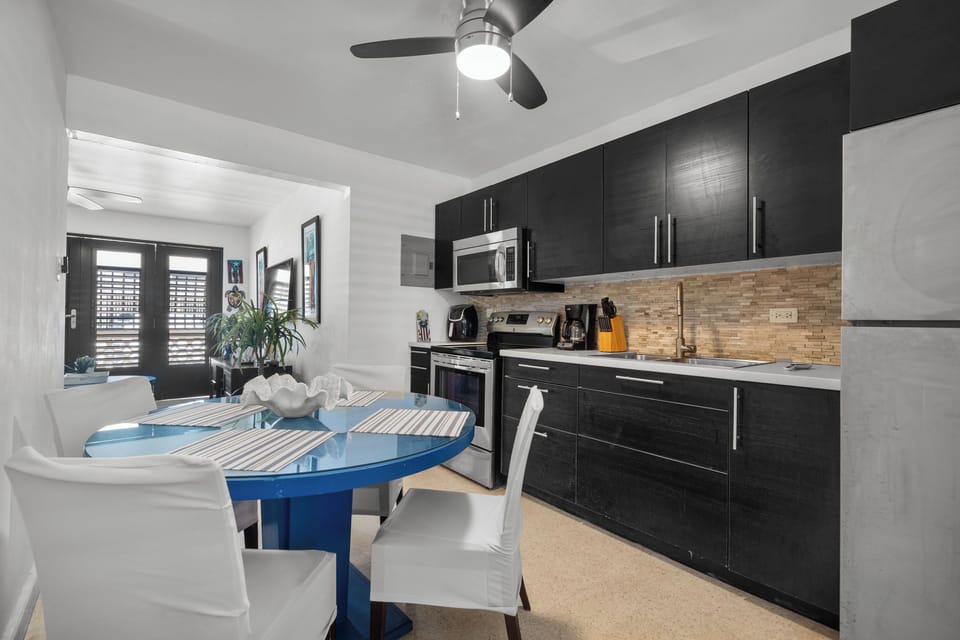 Culinary Delights Await: Our fully-equipped, modern kitchen with an inviting island and seating is perfect for preparing delicious meals and enjoying morning coffee.