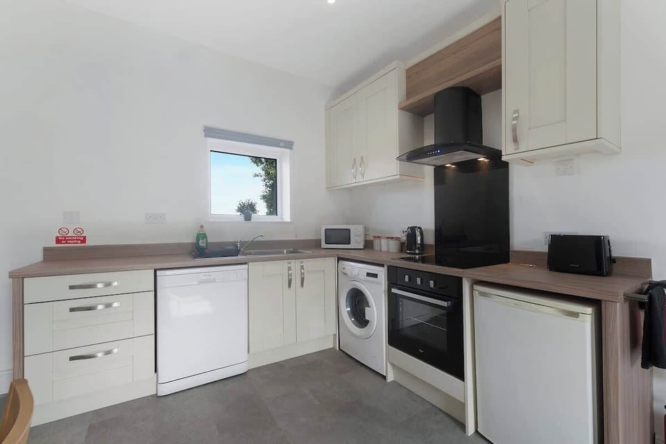 Kitchen equipped with all essentials, including a washer & dryer, oven, mini fridge and full cookware set.