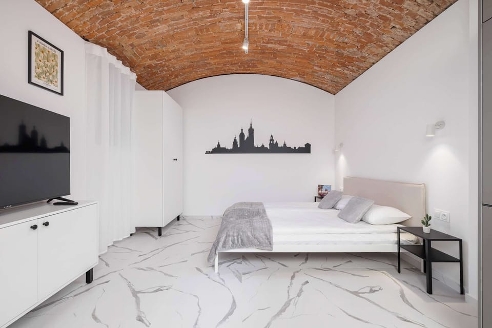 A designer bedroom with a brick-vaulted ceiling and minimalist décor invites relaxation and restful sleep.