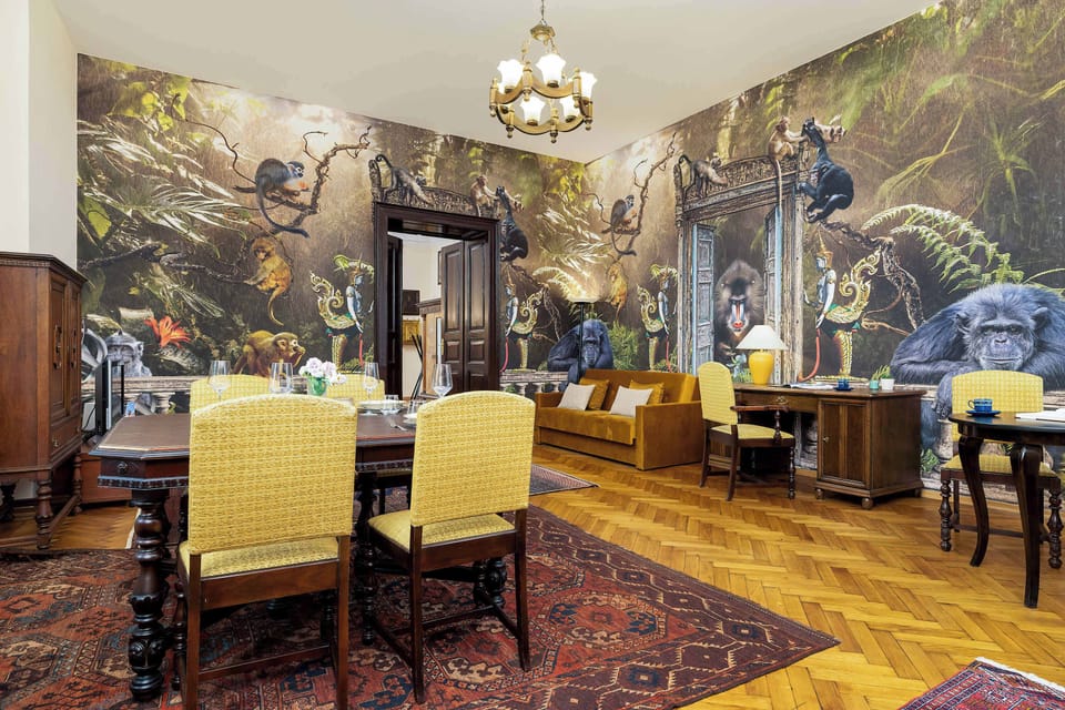 Traditionally decorated bedroom with dining table, chairs, double sofa bed, desk and television.