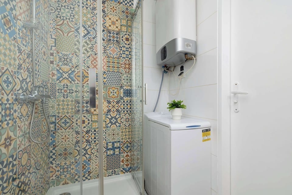 Stylish bathroom with shower, toiletries set, mirror, towels and hair dryer.