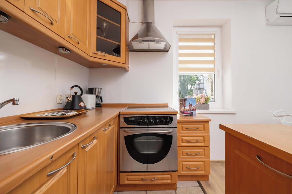 Wooden and cosy kitchenette equipped with an oven, a coffee machine, a toaster and a fridge.