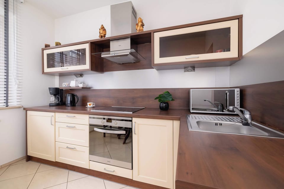 A kitchen area with wooden cabinetry, a stove, and a modern oven, ideal for cooking.