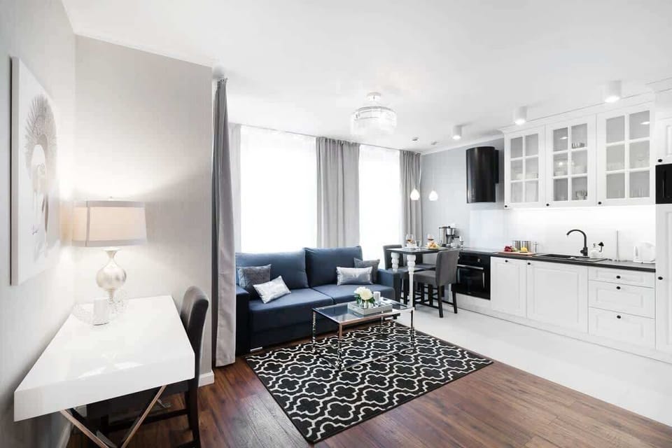 Bright and functional living room with desk for remote work during business trips and practically equipped kitchenette.
