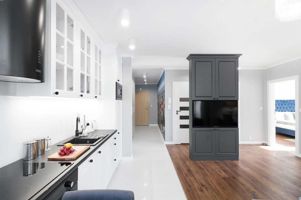 White and classy kitchenette situated in the living room, where the guests can prepare meals and relax in the evening.