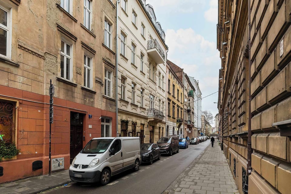  A narrow exterior shot of a building with a modern brick façade. The street view showcases the urban setting of the property.