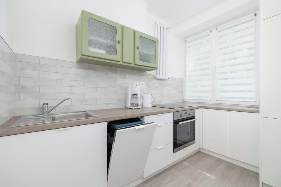 The view of the kitchen with an open dishwasher highlights modern amenities and attention to guest comfort.