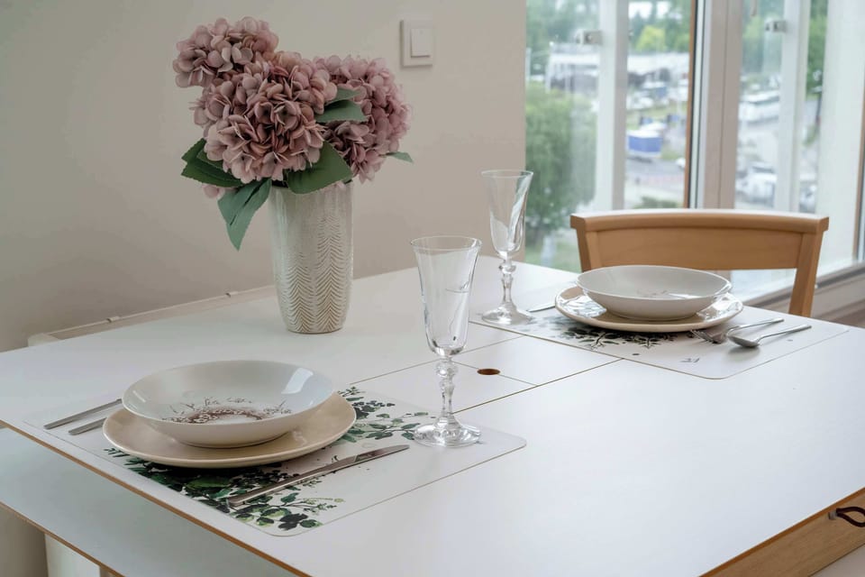 A table set with dishes and fresh flowers invites you to enjoy a homemade meal in an elegant setting.
