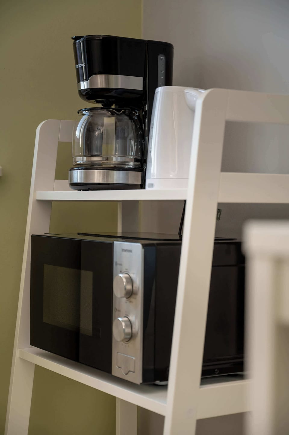 A coffee maker placed on a white shelf, perfect for morning routines.