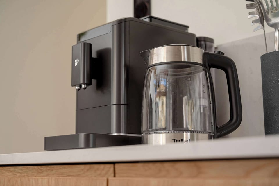 Black coffee machine on wooden top.