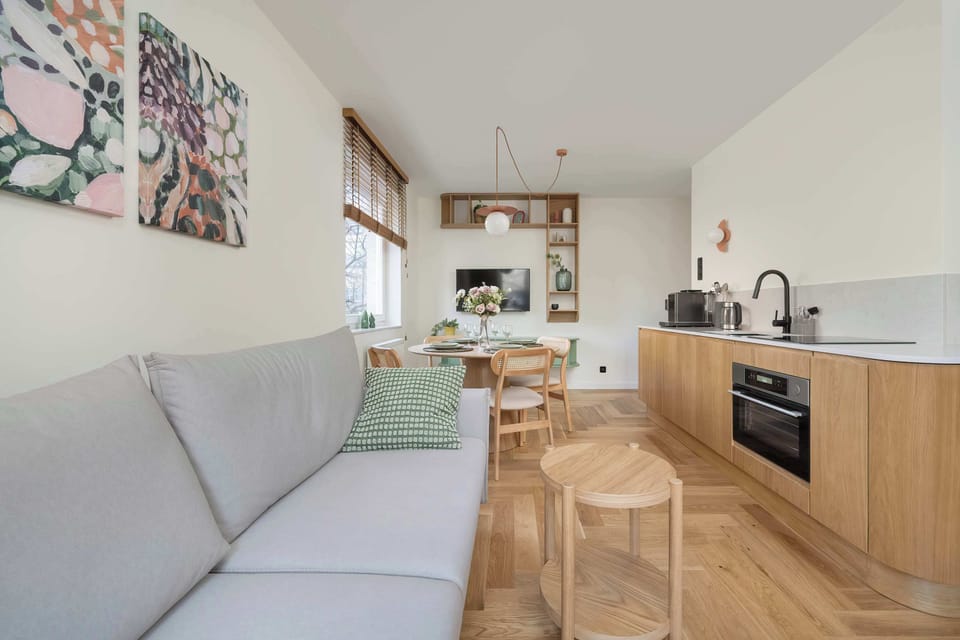 Bright living room with sofa, coffee table and kitchenette in the background.
