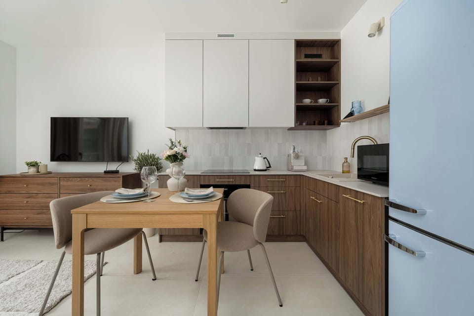 Kitchenette with wooden cabinets, white countertops, and modern appliances.