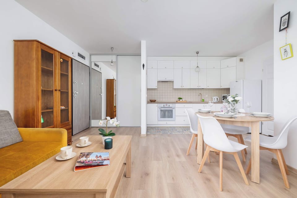 Comfortable living area with sofa, TV and kitchenette with dining table and chairs.