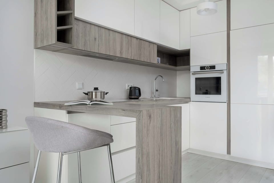 A similar kitchen view with more focus on the cabinetry and the integrated appliances, including a cooktop and oven.