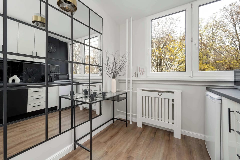A functional kitchen featuring white cabinetry, a black countertop, and a window providing natural light.