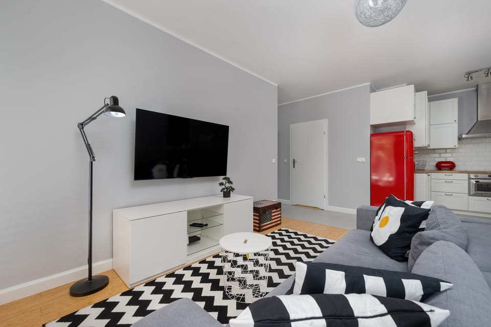 A modern living room with a wall-mounted TV and a comfortable sofa creates the perfect space to unwind after a day of sightseeing.